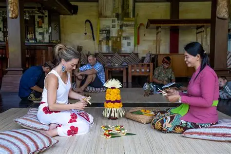 Traveller learning to make traditional Balinese canang sari offerings with a local woman