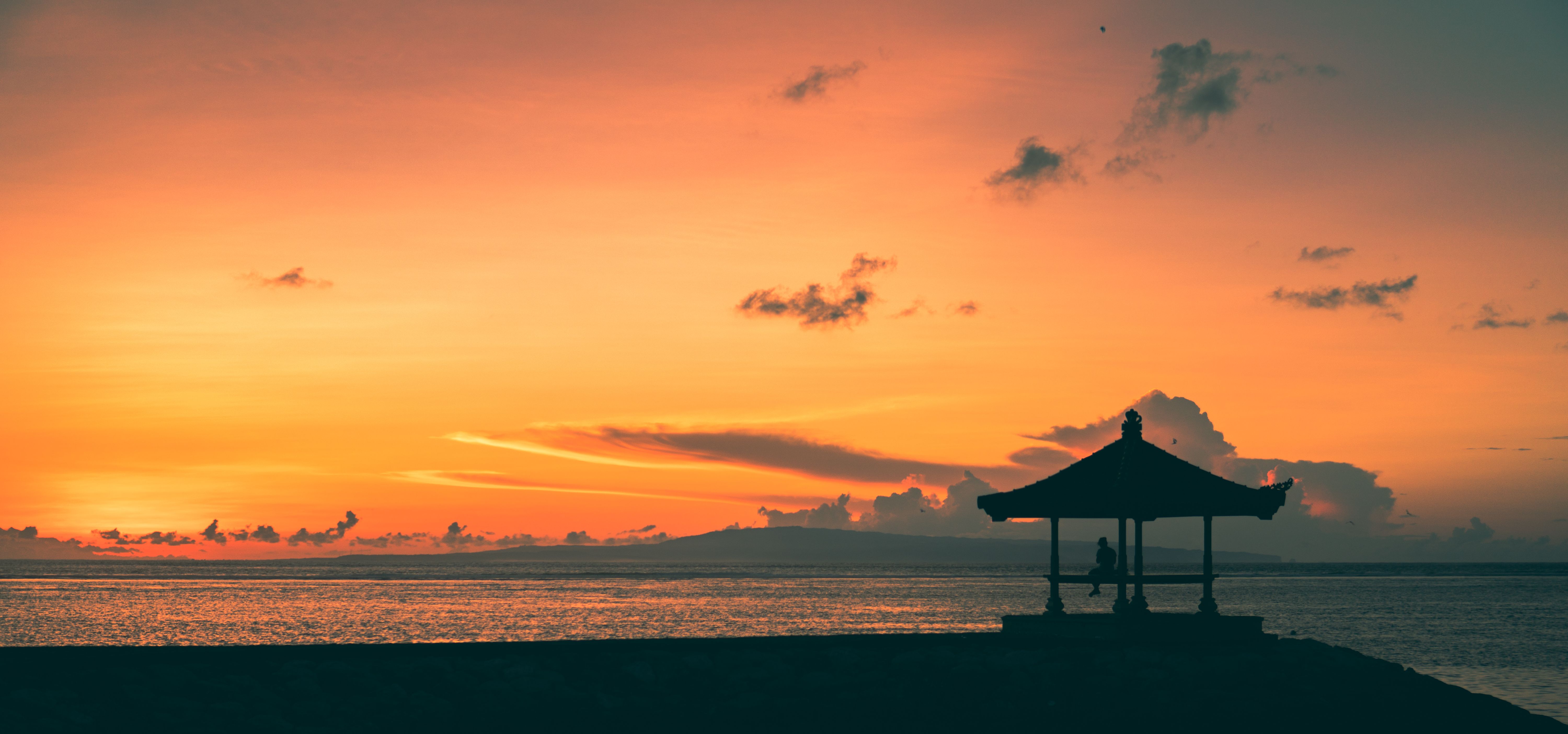 Sanur beach sunset in Bali with calm waters and golden light
